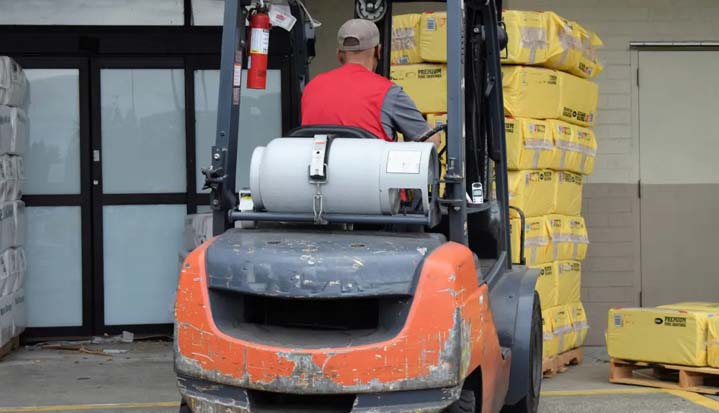 Persona cargando material en una máquina elevadora.